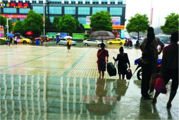 暴雨中,小辣椒服务员冒雨帮旅客抬运行李